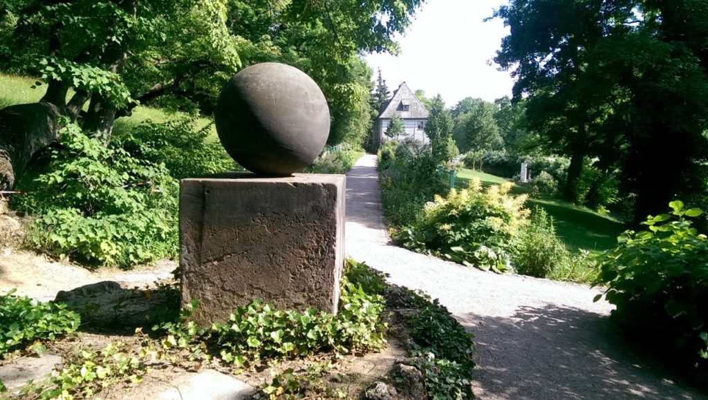 Harmonie in Form und Schlichtheit - das von Goethe entworfene Denkmal "Stein des Glücks" in seinem Garten an der Ilm. Im Hintergrund das Gartenhaus - Goethes erste Wohnung in Weimar .